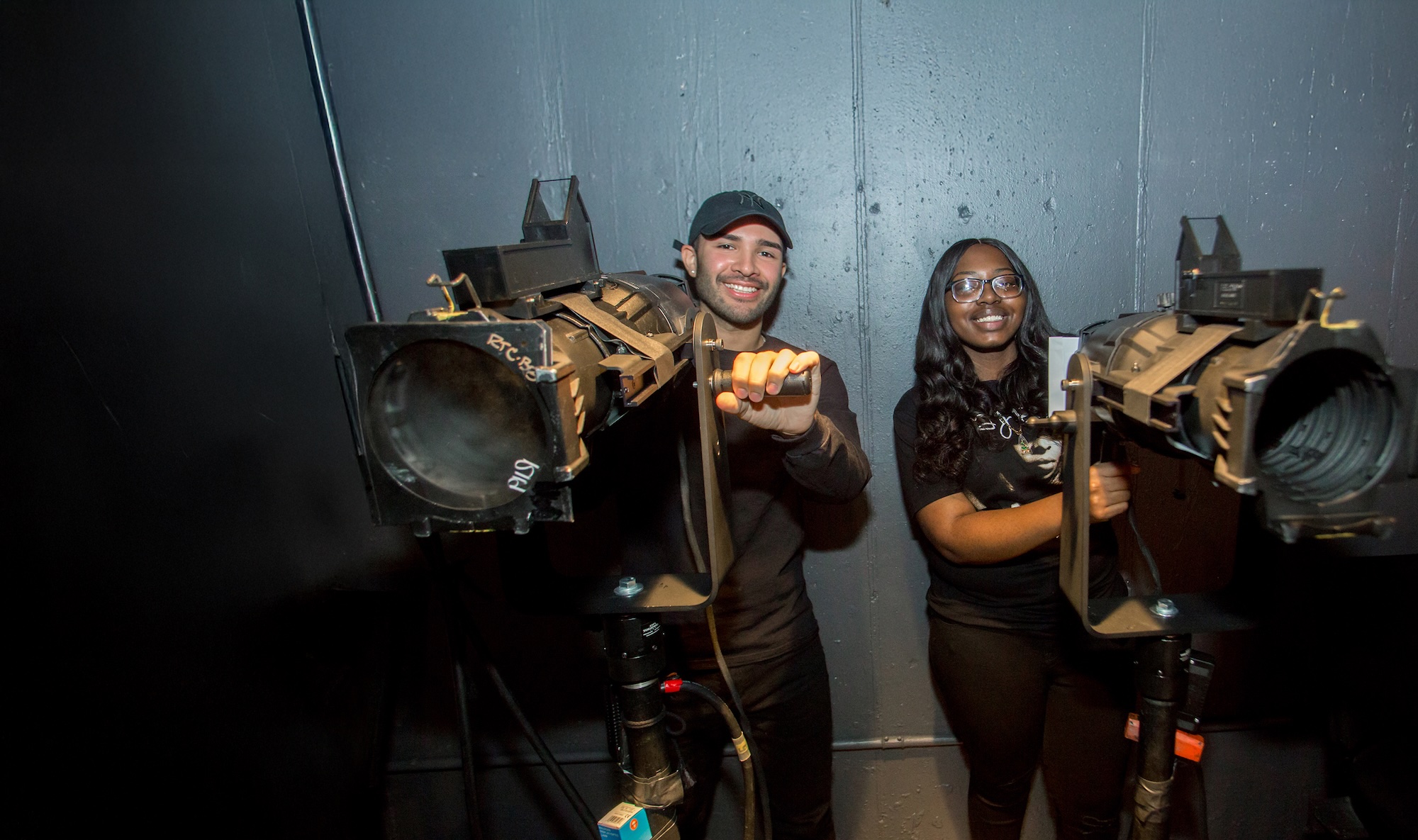 Two students from the Education and Community department operating lighting equipment